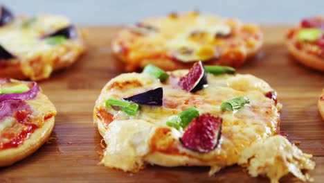 various pizzas on wooden board