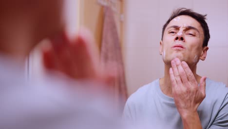 Man applying face cream and cocoa on lips