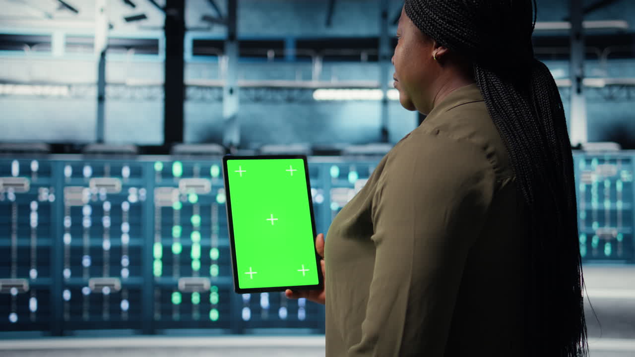 Software developer at work using green screen tablet in data center