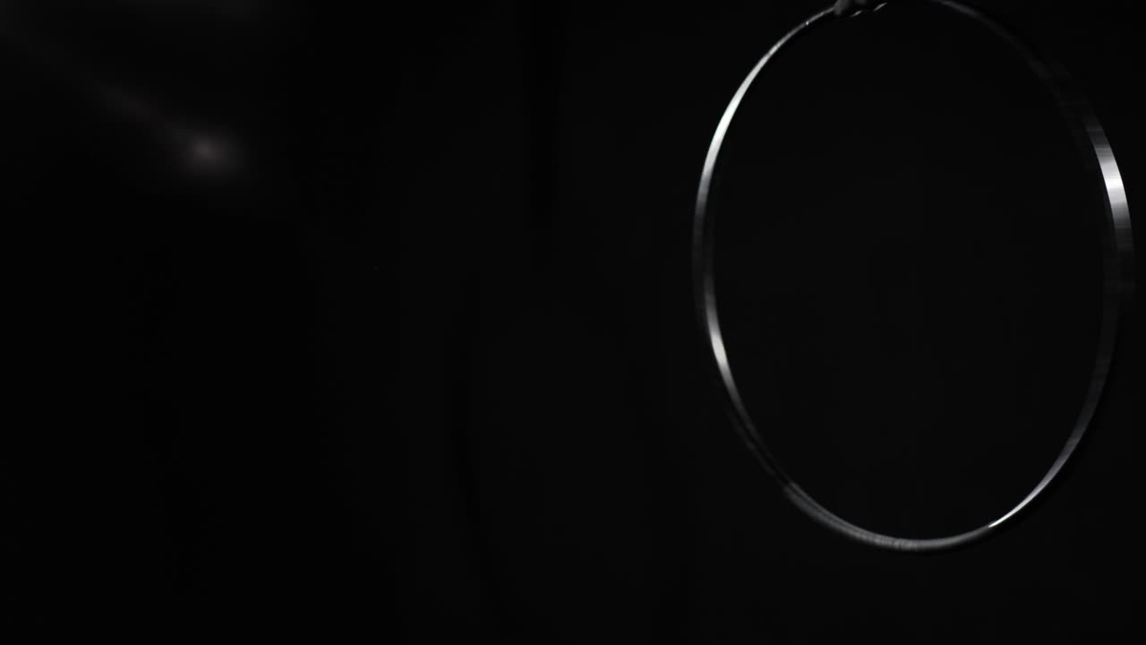 スローモーションで回転する空気ホープ 黒い背景で右側にプロフェッショナルな装備がステージに掛かっている 人のいない テンプレートコンセプト