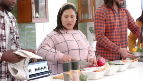 Happy-diverse-male-and-female-friends-preparing-food-together-in-kitchen