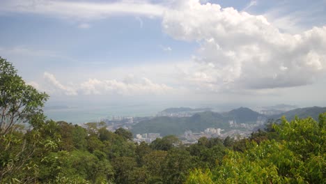 panoramic view of a city nestled among lush mountains and a coastal sea