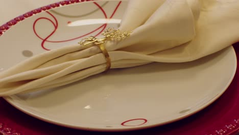 christmas table plate with gold reindeer napkin ring on red and white festive setting