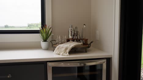 close-up of cocktail shaker, cocktail glasses, and tools on a white countertop