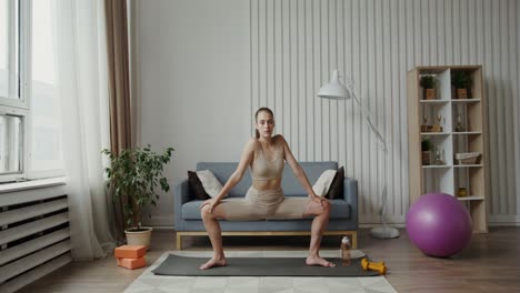 mujer haciendo estiramientos de yoga en casa
