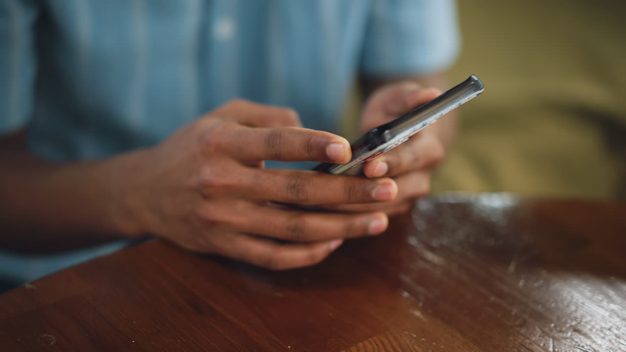 Foggy view of blue shirt and fingers scrolling on mobile, soft focus creating dreamy mood, subtle motion blur, casual interaction with screen, muted light reflections enhancing intimate digital moment
