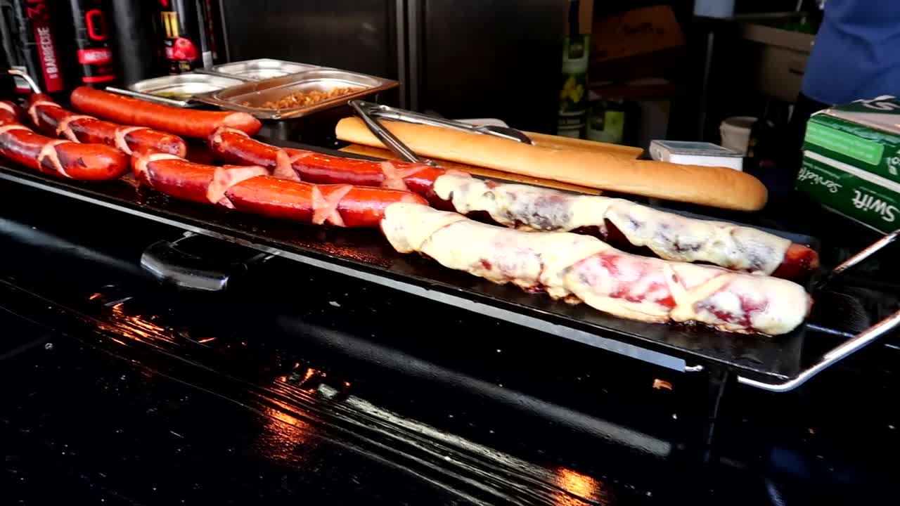 런던의 노점상에서 요리되고 있는 핫도그의 슬로우 모션 패닝 샷