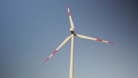 Medium-close-up-shot-of-a-spinning-wind-engine-on-a-sunny-afternoon