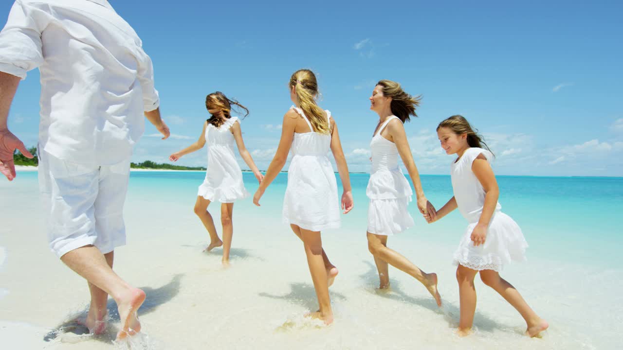 백인 부모와 그들의 어린 딸들이 해변에서