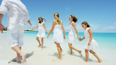 caucasian parents and their young daughters on beach