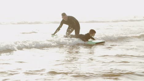 father teaching son swimming on board