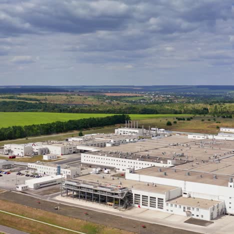 factory on nature background. modern large industrial complex on field in summer. manufacture among green landscape. aerial view