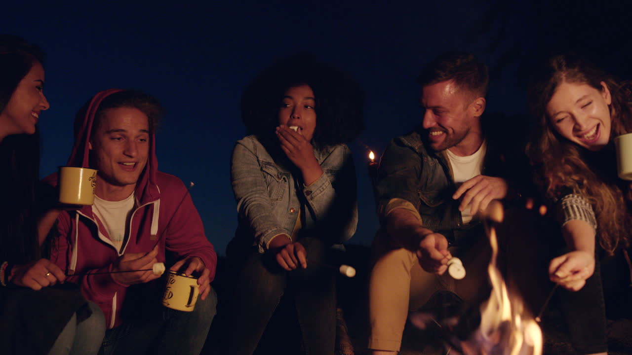 amigos reunidos alrededor de una fogata para