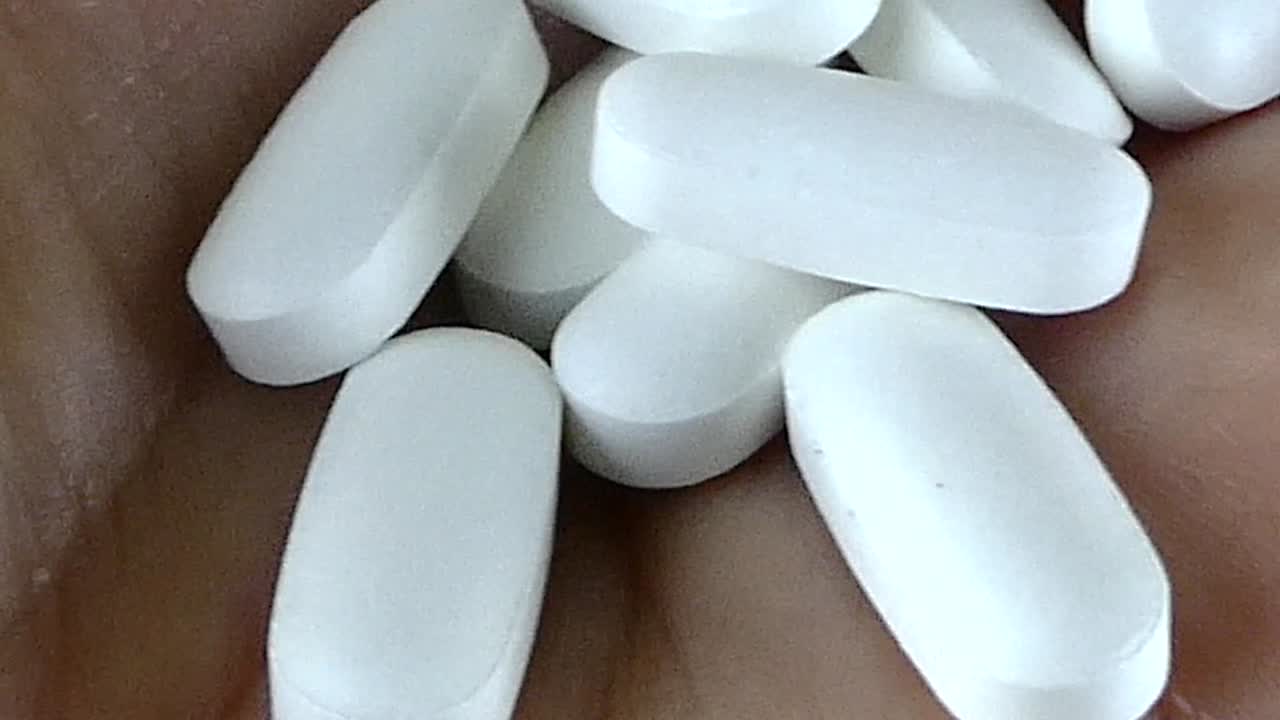 Close-up of a Handful of White Oval Pills