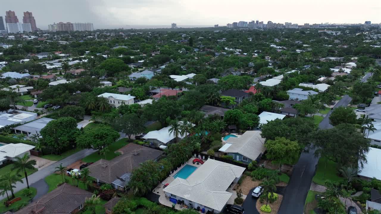 Aerial View of a Green Residential Neighborhood with City Skyline in the Background