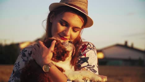 Stunning-HD-footage-of-a-white-Caucasion-girl-with-a-knitted-hat-and-red-lipstick-holding-a-dog-Cavalier-King-Charles-Spaniel-in-her-arms,-hugging-and-caressing-it