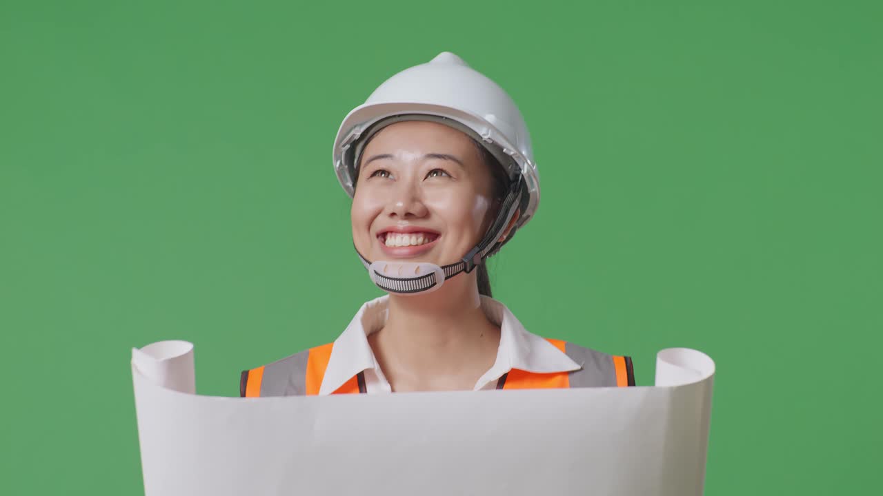 미소 짓는 여성 엔지니어가 건축 계획을 검토하고 있습니다.