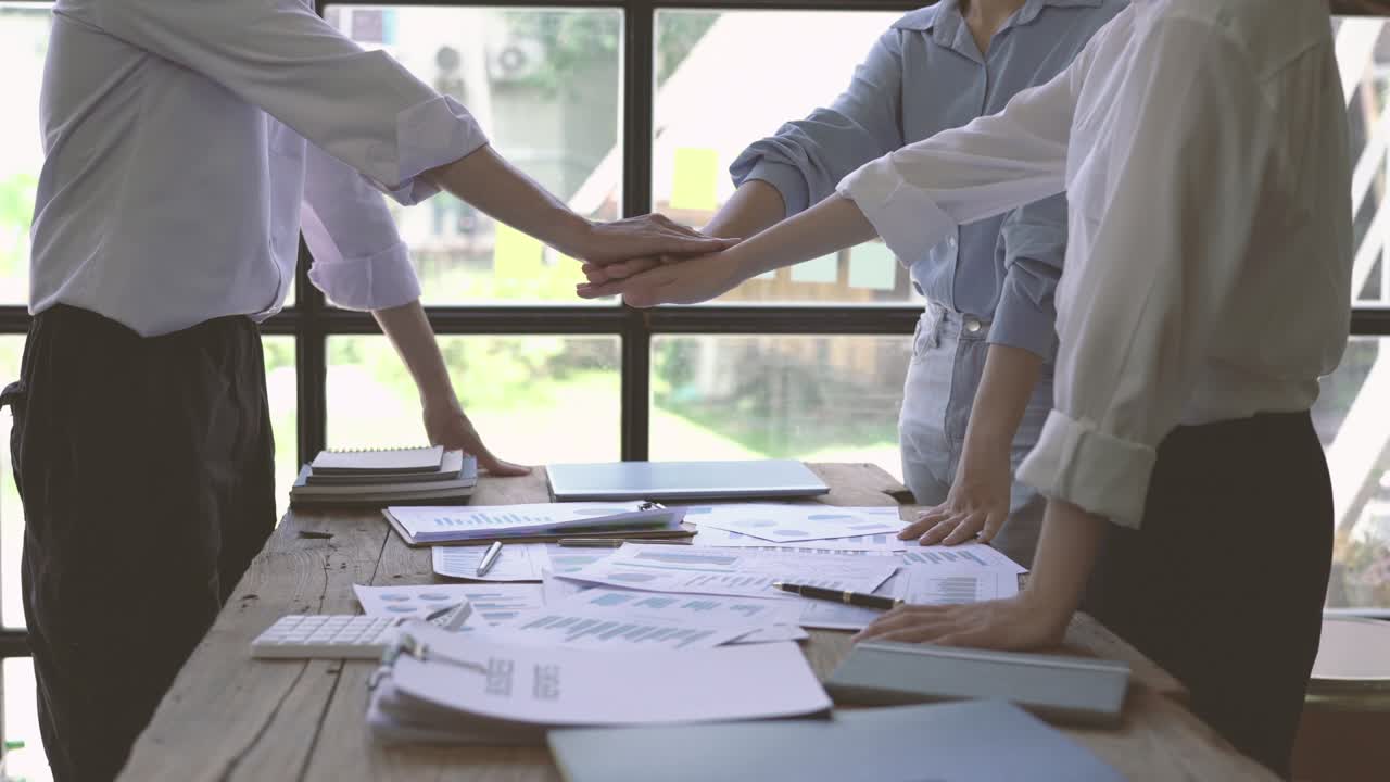 jóvenes hombres y mujeres de negocios asiáticos felices que se reúnen para intercambiar ideas sobre nuevos proyectos de papeleo.