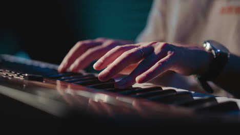 el arreglista se involucra con el sintetizador en primer plano. el músico experto compone la melodía usando un instrumento musical en el estudio de grabación de audio. tonos melódicos