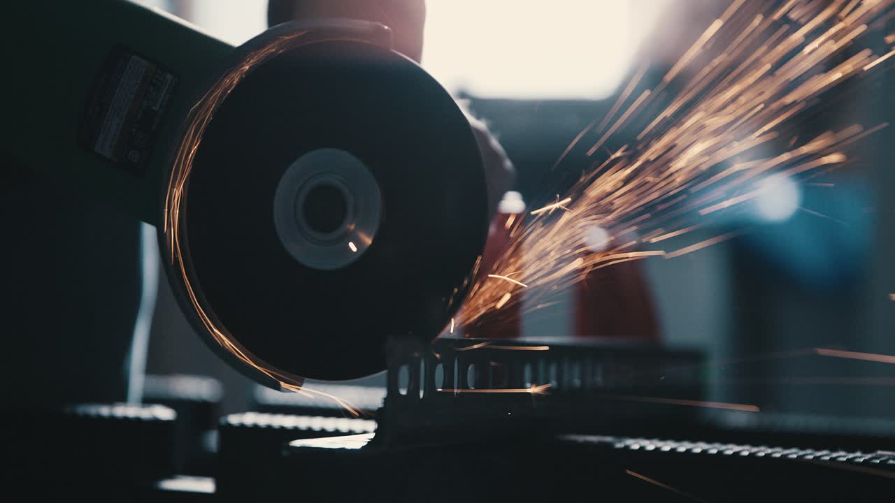 Close up of angle grinder cutting into metal bracket slow motion