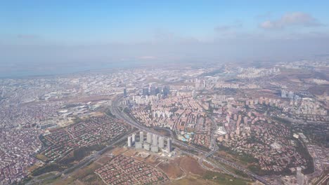 Vista-Cinematográfica-Diurna-De-La-Ciudad-De-Estambul-A-Través-De-La-Ventana-Del-Avión,-Que-Presenta-Un-Bullicioso-Paisaje-Urbano-Con-La-Autopista-E80-Entre-Edificios-Abarrotados-En-Esenyurt.