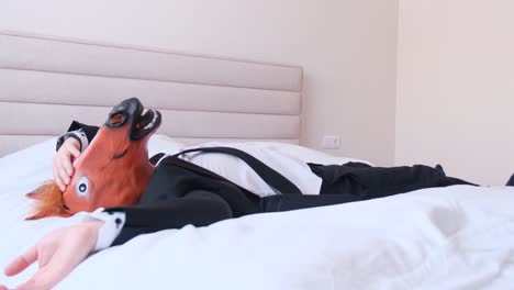 man in a horse mask lying in bed