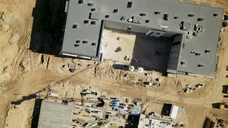 top down zoom out from construction site with building crane and big shadow of them