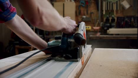 slow motion. the master cuts a wooden board with a circular saw in the woodworking workshop of a small furniture manufacturer.