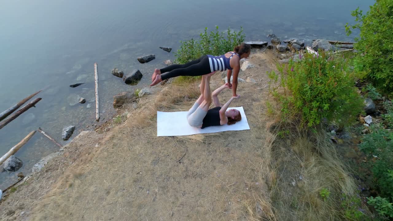 Göl kenarında akroyoga yapan çift 4K