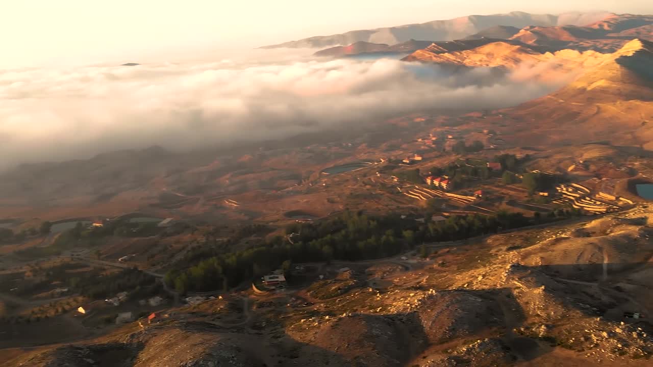 Aerial drone footage capturing misty lakes and cloud formations at sunset, revealing nature's tranquil beauty from above