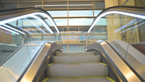 going up modern escalator at airport