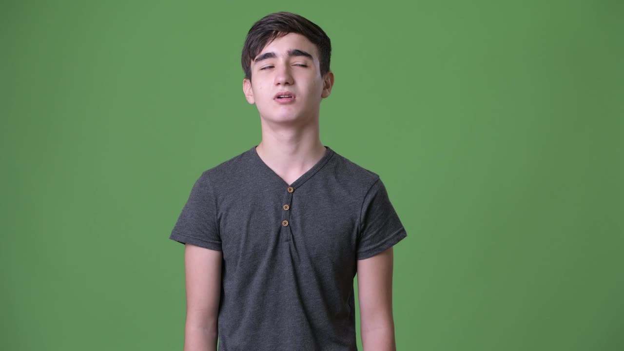초록색 배경에 젊은 잘생긴 이란 십대 소년