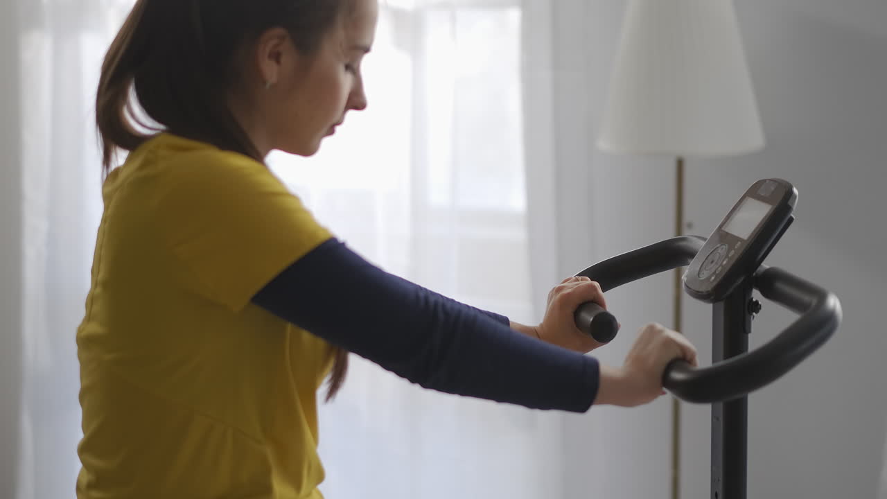 스포츠 여성은 집에서 스테이션 자전거로 훈련하고 스포츠와 피트니스 건강한 생활 방식과 체중 감소 신체 운동