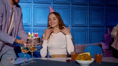 feliz cumpleaños mujer soplando velas en el pastel haciendo deseos, divirtiéndose, celebrando la fiesta con la familia
