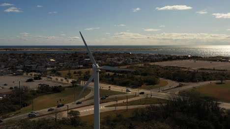 drone orbiting counterclockwise around a white wind turbine