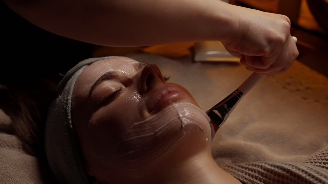 Zbliżenie kobiety poddającej się zabiegowi z maską na twarz w spa