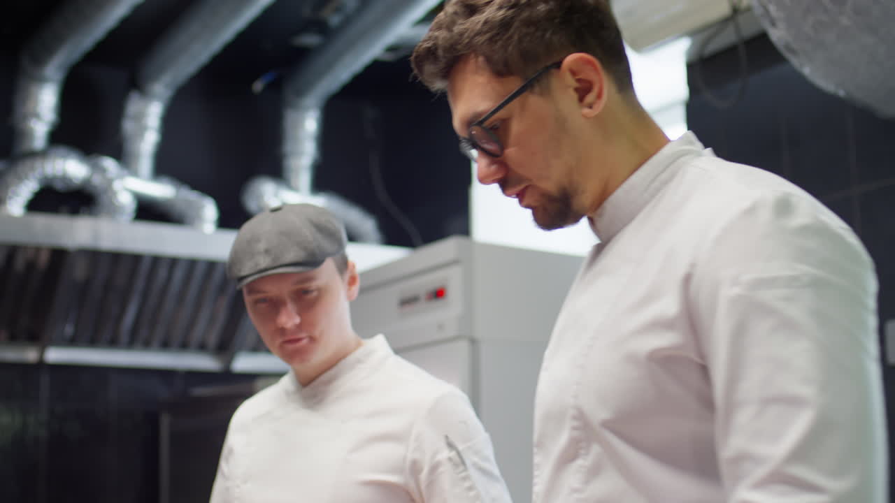 Chef Doing Food Inventory with Colleague in Restaurant Kitchen