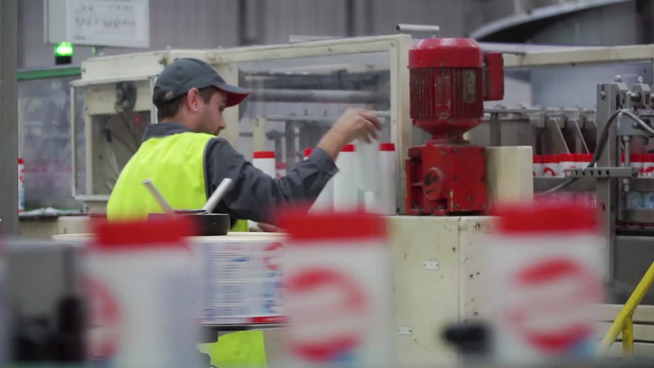 Factory worker operating a packaging machine