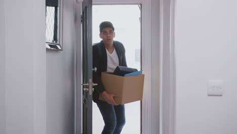 Male-College-Student-Carrying-Box-Moving-Into-Accommodation