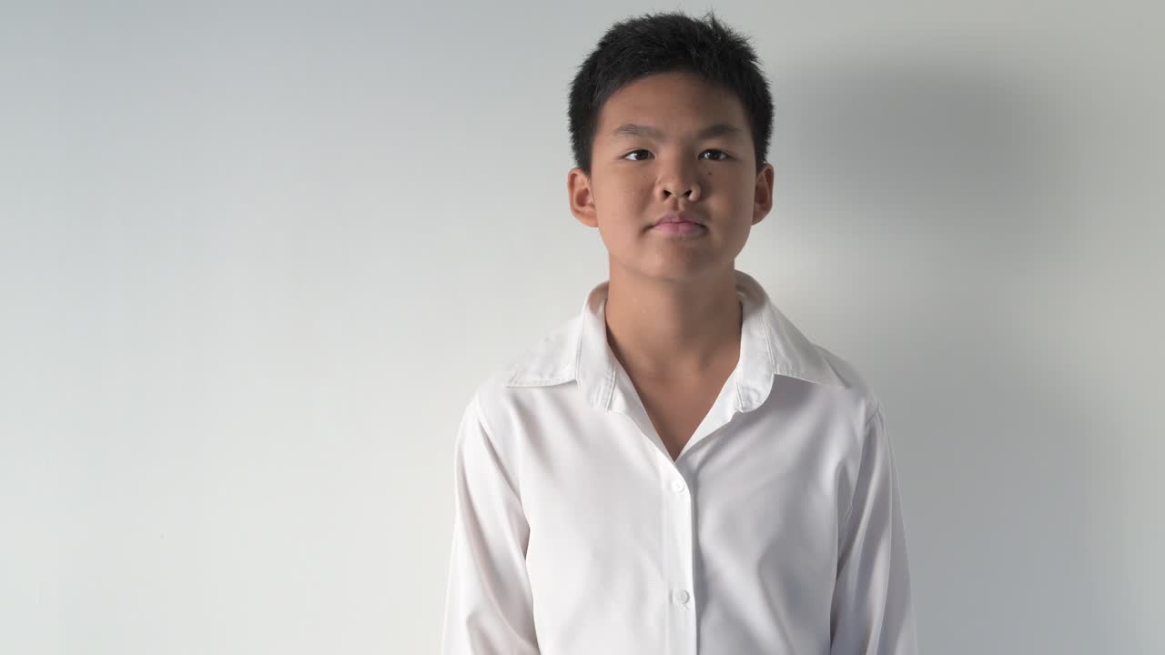 Portrait of confident Asian teenage boy giving thumbs up gesture of approval