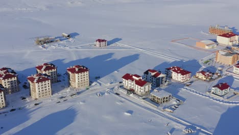 drone flying over snow covered apartment buildings in rural sarikamis kars turkey