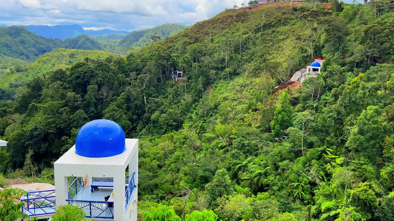 Bright blue-domed pavilion set against dense tropical hills—perfect for eco-tourism, architecture, or travel inspiration