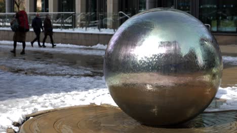 una fuente artística, esférica, artística, de metal que cae agua en cascada en el centro de la ciudad de sheffield