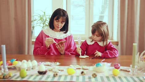 mother and daughter decorating easter cookies