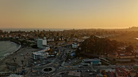 Santa-Cruz-California-Aerial-V10-Fliegt-über-Die-Beach-Street,-Die-Zum-West-Cliff-Drive-Führt,-Flyover-Kreisverkehr-Am-Wharf-Eingang,-Große-Leuchtende-Sonne,-Die-In-Der-Skyline-Untergeht-–-Aufgenommen-Mit-Mavic-3-Cine-–-Mai-2022