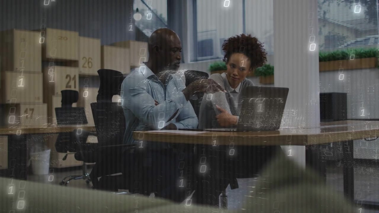 Un uomo che indica il laptop e spiega l'informatica, attivando un'interfaccia binaria in espansione mentre una donna ascolta.