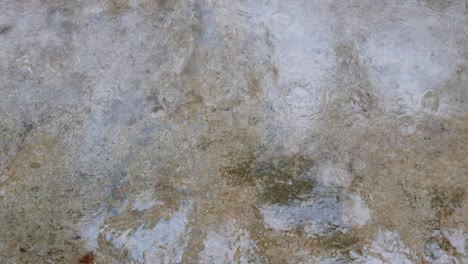 gotas de lluvia cayendo sobre el suelo de hormigón sucio y húmedo en un día lluvioso