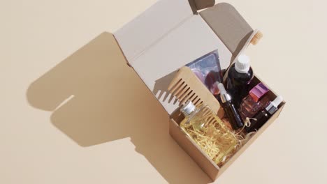 video of beauty products in cardboard box with copy space over brown background