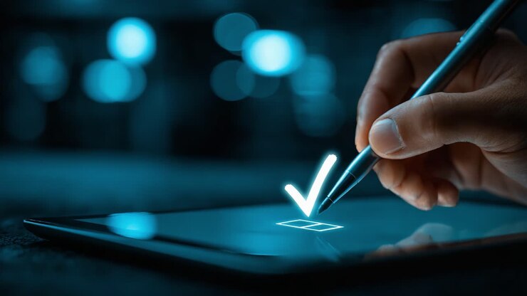 A hand utilizes a digital pen to mark a checkbox on a tablet screen, signifying confirmation or approval in a modern, tech-savvy environment with a serene blue glow
