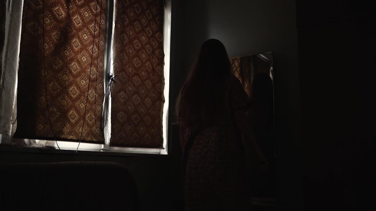 cinematic scene showing a mentally unstable woman staring into a mirror in a decayed room. Ideal for horror visuals, psychological thriller clips, and Halloween-themed media